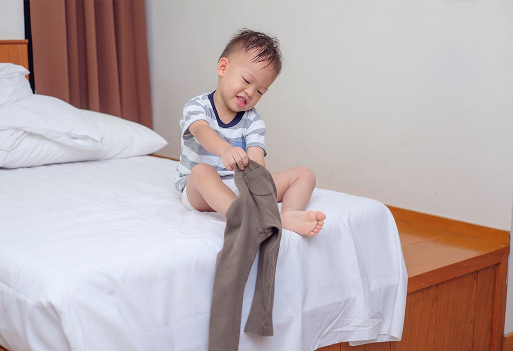 Toddler taking off his clothes